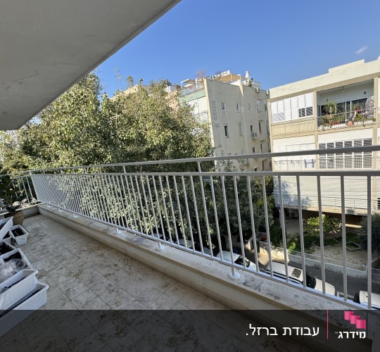 מעקה מתכת לבן במרפסת עם רצפה מלוכלכת